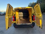 the back of a yellow van with its doors open in a parking lot