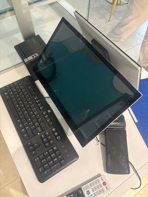 une table en verre sur laquelle sont posés un ordinateur portable et un clavier