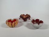 three small glass bowls sitting next to each other on a white surface