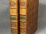 two old books sitting on top of each other on a table