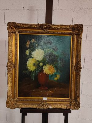 une photo d'un tableau représentant des fleurs dans un vase, posé sur un chevalet