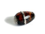une image représentant une bague marron et noire ornée d'un anneau argenté