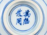 a close up of a blue and white plate with writing on it