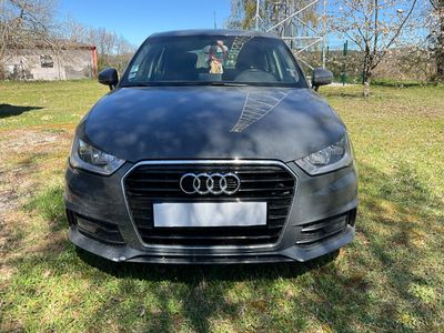 the front of a black audi car parked in a grassy field