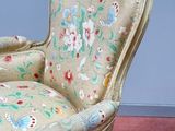 a chair with a floral upholstered seat on a pink floor