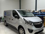 a silver van parked in a warehouse with boxes and boxes in the background