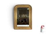 a gold framed mirror on the wall above a table