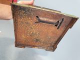 a hand that is holding a metal box with a handle