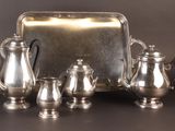 a silver tray with a silver tea set on it