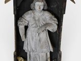 an old statue of a woman holding a bird in a birdhouse