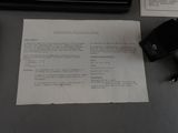 a piece of paper sitting on a desk next to a keyboard