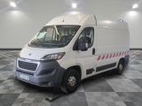 la camionnette blanche est garée sur un sol en damier dans le garage