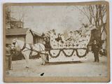 an old photo of a group of people riding in a horse drawn carriage