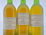 trois bouteilles de vin sont alignées sur une surface blanche