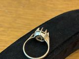 silver ring with a cat ' s head on top of it on a black case