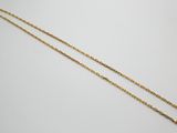 un collier à chaîne en or orné d'un petit diamant