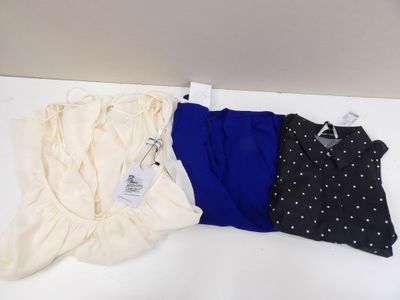 trois hauts pour femme posés sur une table blanche à motifs à pois