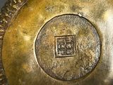 a close up of a gold plate with a design on it