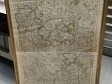Une vieille carte de l'Europe est exposée dans un cadre posé à même le sol.