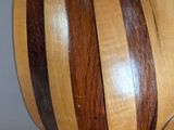 a close up of a wooden object with a guitar in the background