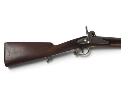 un vieux fusil avec un canon en bois et des garnitures en laiton