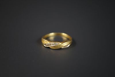 gros plan d'une bague en or avec des diamants sur une surface noire