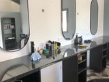 une photo d'un salon de coiffure avec des miroirs accrochés au mur