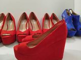 several pairs of red and blue shoes are lined up on a shelf