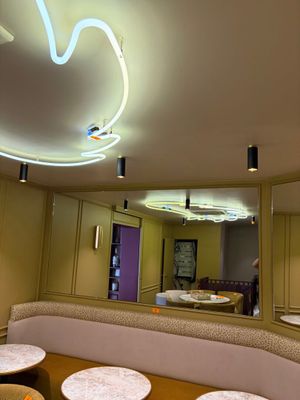 un miroir au milieu d'une pièce où se trouvent des tables et des tabourets