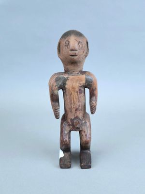 une petite figurine en bois représentant un homme torse nu