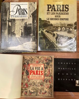 Plusieurs livres sont posés sur une table, à côté d'une tasse de café