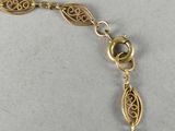 a close up of a gold bracelet with a chain on it