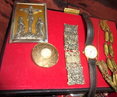 une boîte rouge sur laquelle sont posés une montre, un bracelet et d'autres objets