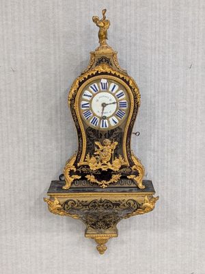 a clock that is hanging on the wall with a bird on it