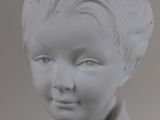 white marble bust of a boy with curly hair and blue eyes