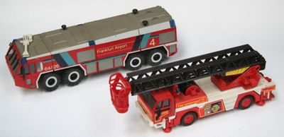 deux camions de pompiers miniatures posés l'un à côté de l'autre sur une surface blanche
