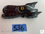 une petite voiture miniature sur laquelle est représentée la Batmobile