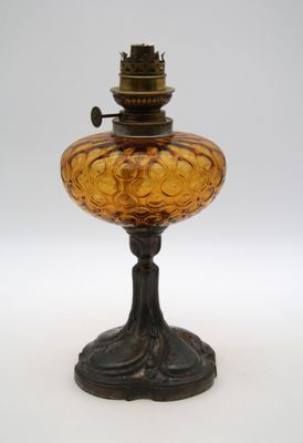 une lampe à huile à l'ancienne posée sur une surface blanche, avec un fond blanc