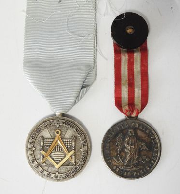 deux médailles et une médaille sur une surface blanche