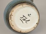 a close up of a blue vase with writing on it