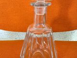 une bouteille en verre transparent surmontée d'un bouchon en verre