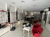 many glasses on display in a store with red chairs