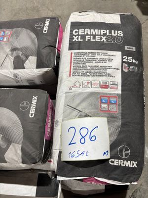 trois sacs de ciment posés par terre les uns à côté des autres