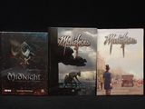 trois livres posés sur une table noire