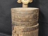 a close up of a wooden box with a face on top