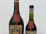 two bottles of liquor sitting next to each other on a white surface