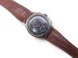 wrist watch with brown leather strap on white surface with white background