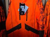 une veste orange accrochée à un portant dans un magasin de vêtements