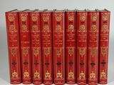 six red books are lined up in a row on a white surface