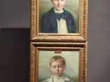 two paintings of a boy and a girl are on display in a museum